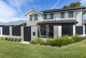Image of black aluminium slat fencing surrounding a double story modern home