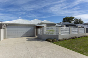 Image of grey aluminium slat fencing surrounding a single story modern home