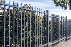 Image of a commercial security fence with shrubs behind
